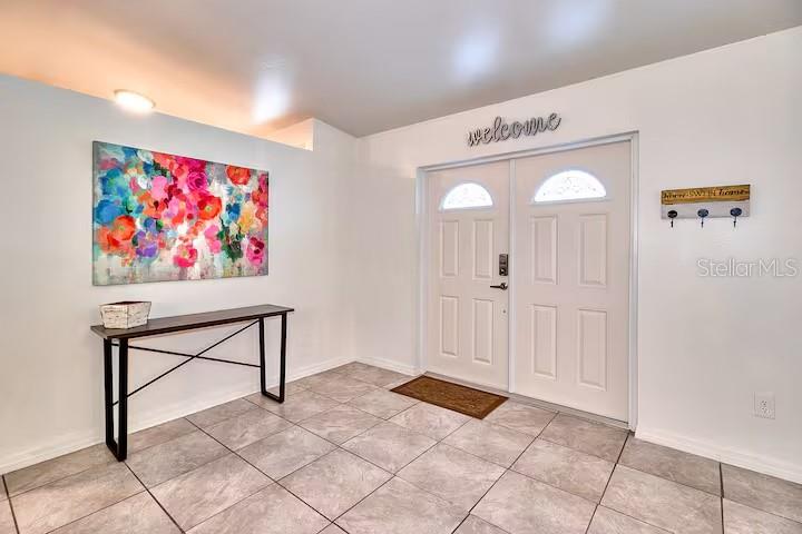 A covered porch features a white double front door, a side door, and gray flooring — 2804 N 33RD STREET, TAMPA, FL