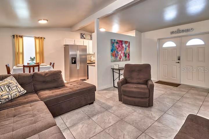 A living room features a gray sectional sofa, a matching recliner, and a wall-mounted television — 2804 N 33RD STREET, TAMPA, FL