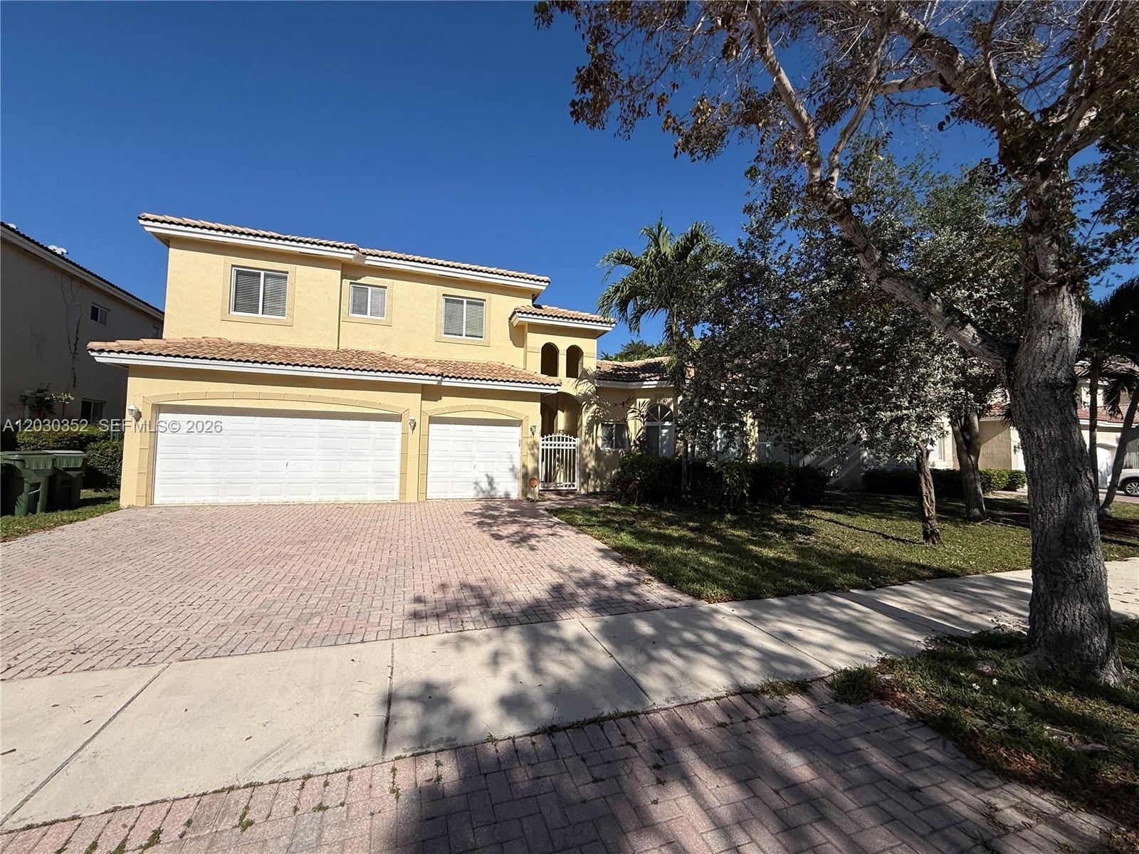 A two-story yellow house with a tiled roof and a paved driveway — 2250 SE 19th Ave, Homestead FL 33035, HOMESTEAD, FL