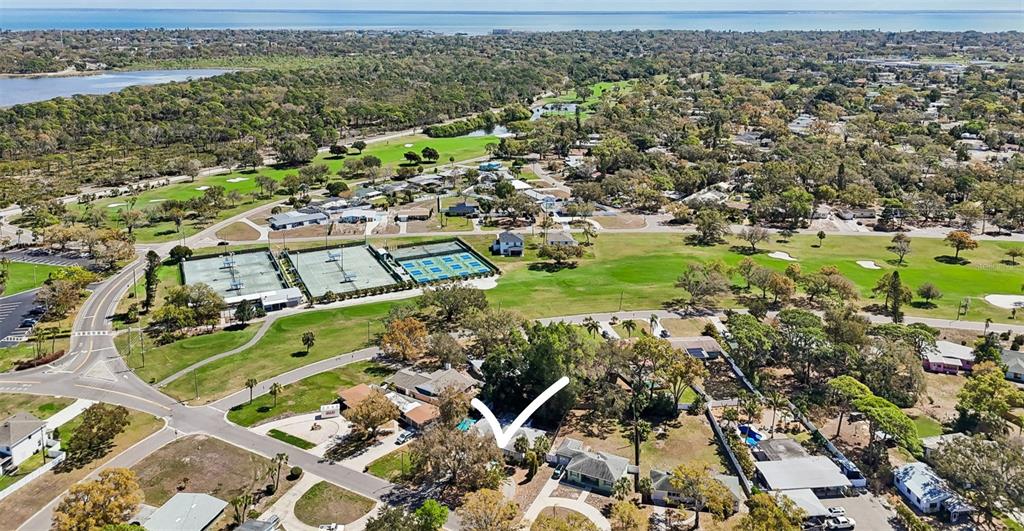 An aerial view shows a residential neighborhood with a house highlighted by a white arrow — 2120 CORONADA WAY S, ST PETERSBURG, FL