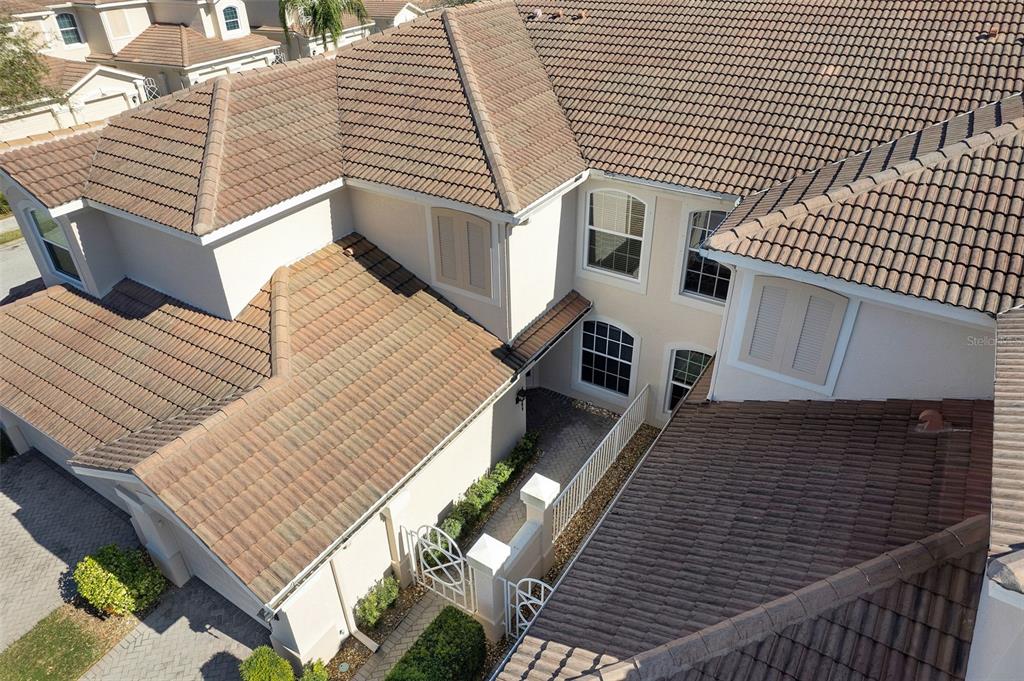 An aerial view shows the tiled roof and exterior of a multi-story residential home — 4533 CINNAMON DRIVE UNIT 2707, SARASOTA, FL