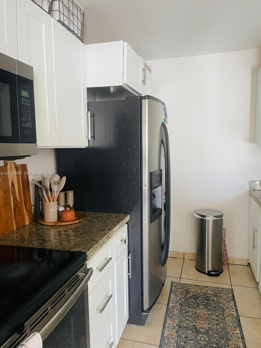 A kitchen features white cabinets, granite countertops, stainless steel appliances, and a tile floor — 10393 N Kendall Dr # U6, Miami FL 33176, MIAMI, FL