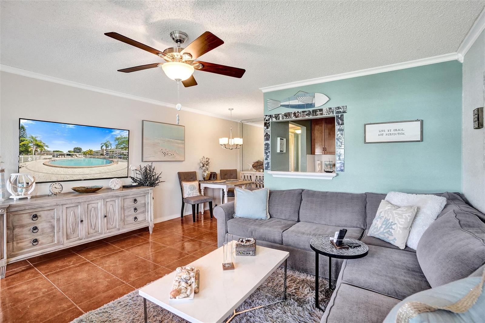 A living room features a grey sectional sofa, a television, and terracotta tile flooring — 227 Tilford K # 227, Deerfield Beach FL 33442, DEERFIELD BEACH, FL