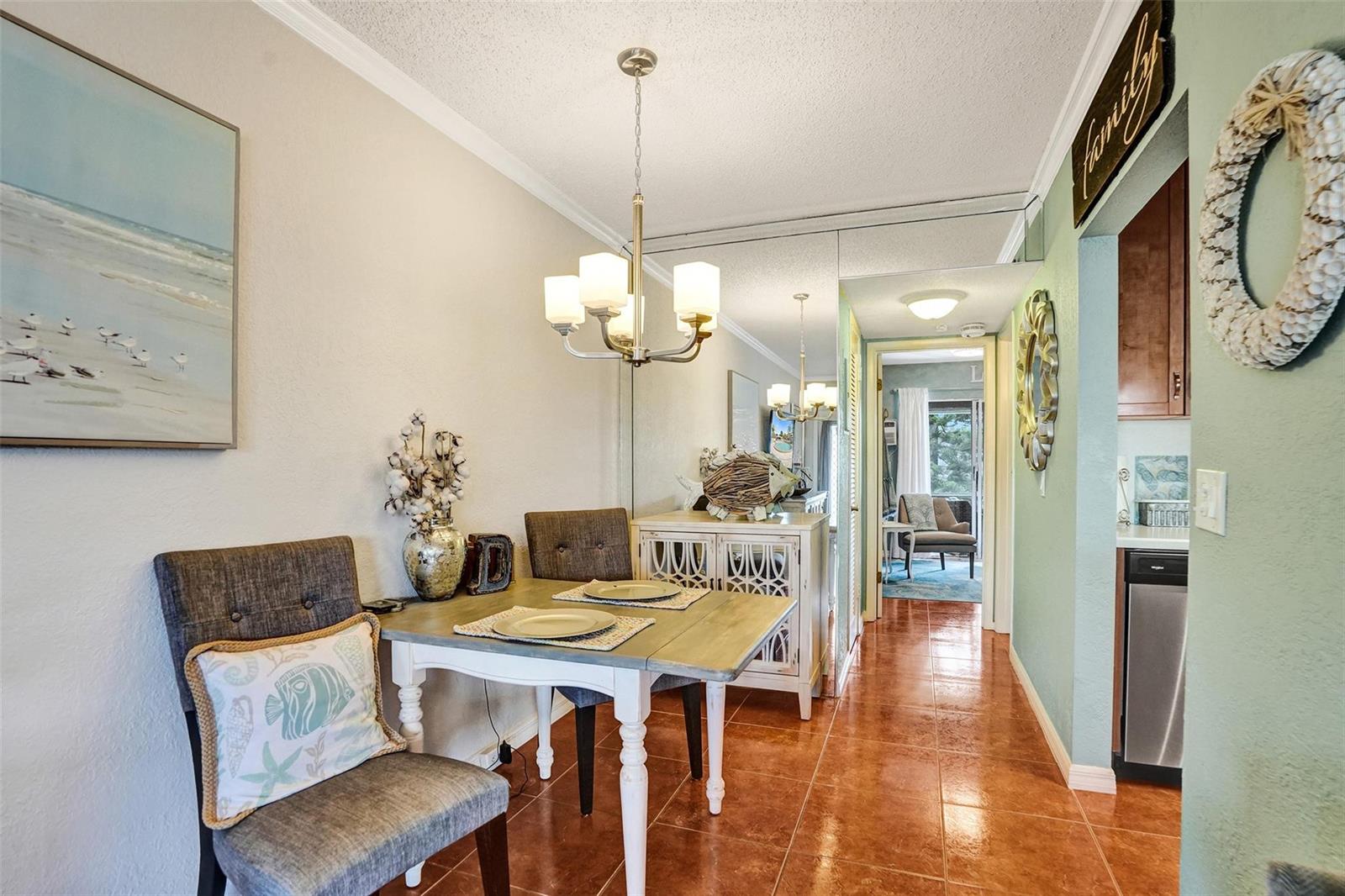 A dining area features a small table, two chairs, a chandelier, and a mirrored wall — 227 Tilford K # 227, Deerfield Beach FL 33442, DEERFIELD BEACH, FL