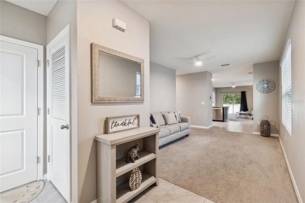 A view of a living room with beige carpet, a console table, and a sofa — 5221 HILLSIDE MEADOW PLACE, TAMPA, FL