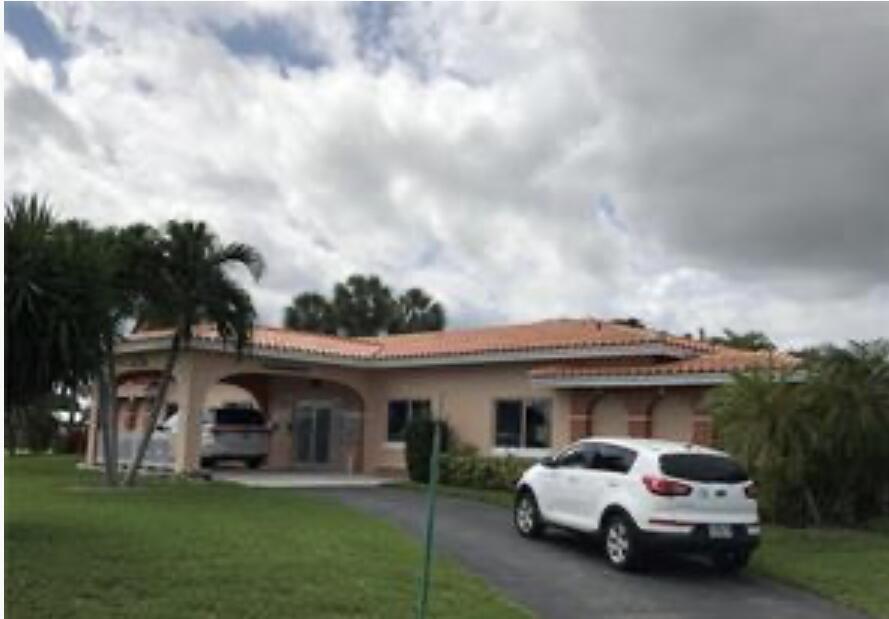 A single-story peach-colored house with a tile roof, a covered entryway, and a driveway — 4803 Highland Drive, Tamarac FL 33319, TAMARAC, FL