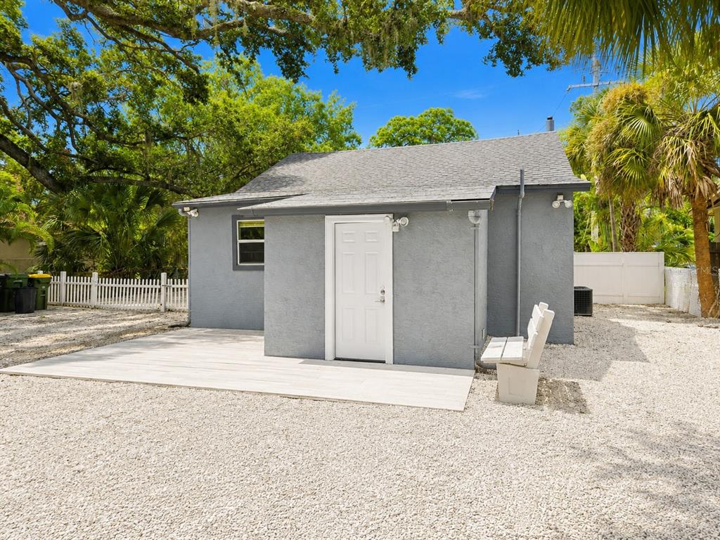 A gray detached building with a white door, a small patio, and a gravel yard — 1235 32ND STREET, SARASOTA, FL