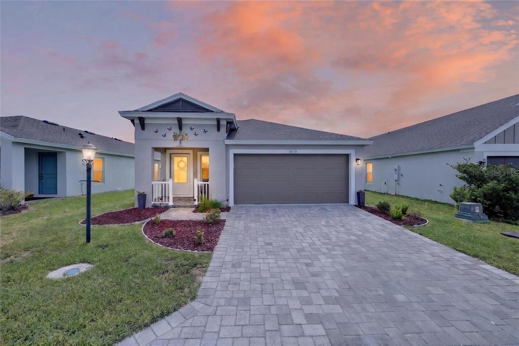 A single-story house with a paved driveway, a two-car garage, and a small front porch — 9619 SW 62ND COURT, OCALA, FL