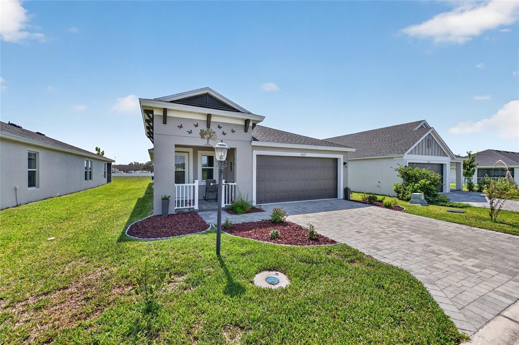 A single-story house with a gray stucco exterior, a two-car garage, and a paved driveway — 9619 SW 62ND COURT, OCALA, FL