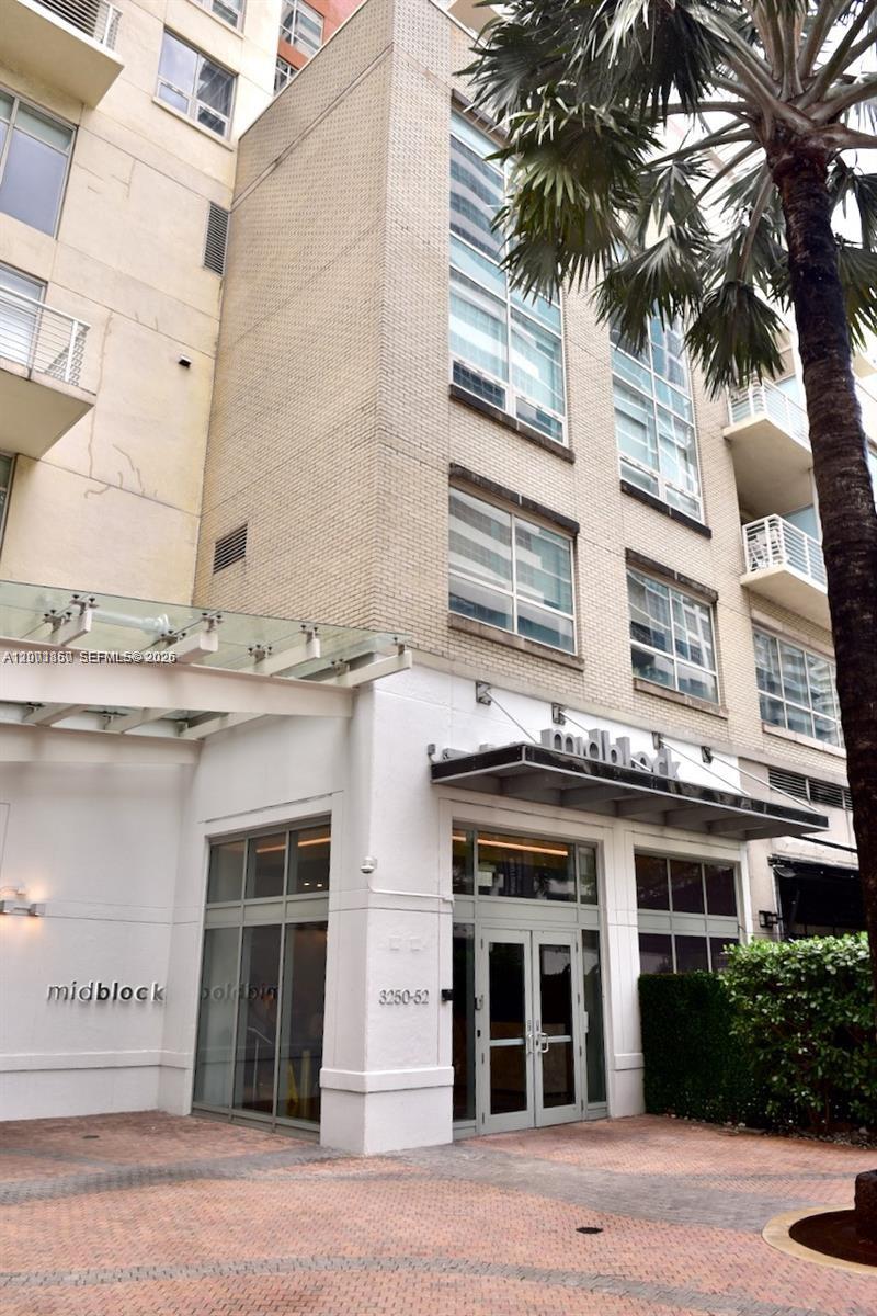 The exterior of a multi-story building features a glass-covered entrance and a brick facade — 3250 NE 1st Ave # 321, Miami FL 33137, MIAMI, FL
