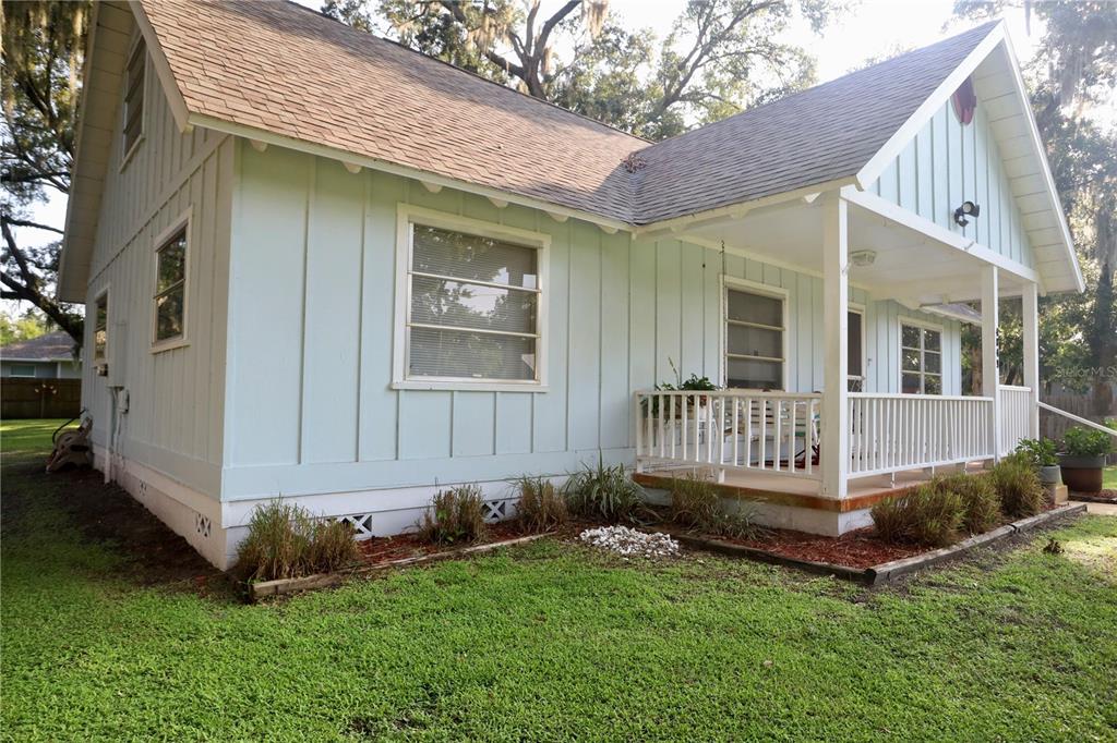 A light blue house with vertical siding, a front porch, and a shingled roof — 4849 MEADOW DRIVE, ST CLOUD, FL