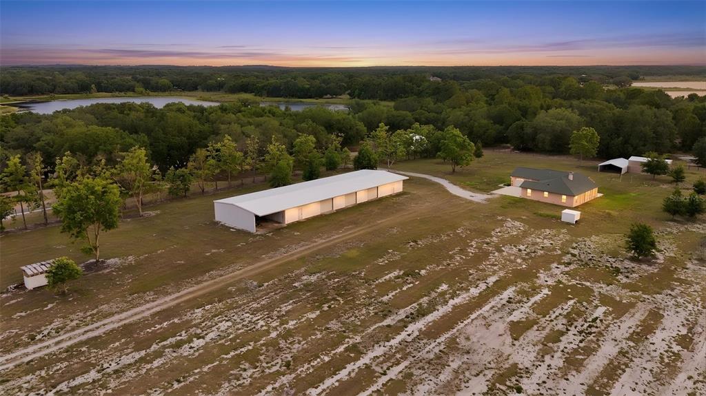 An aerial view shows a long metal barn, a house, and outbuildings on a rural property — 14433 LAKE YALE ROAD, UMATILLA, FL