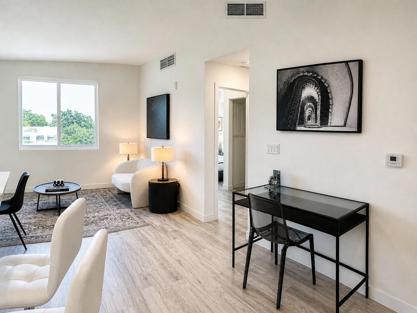 A living area with a desk, white chairs, a round coffee table, and wall art — 1621 S Dixie Highway, Pompano Beach FL 33060, POMPANO BEACH, FL