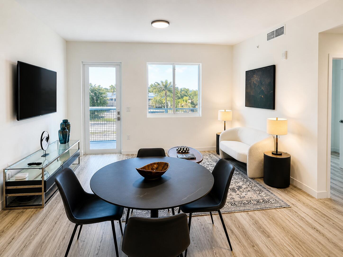 A living and dining area features a round black table, white sofa, and balcony door — 1621 S Dixie Highway, Pompano Beach FL 33060, POMPANO BEACH, FL