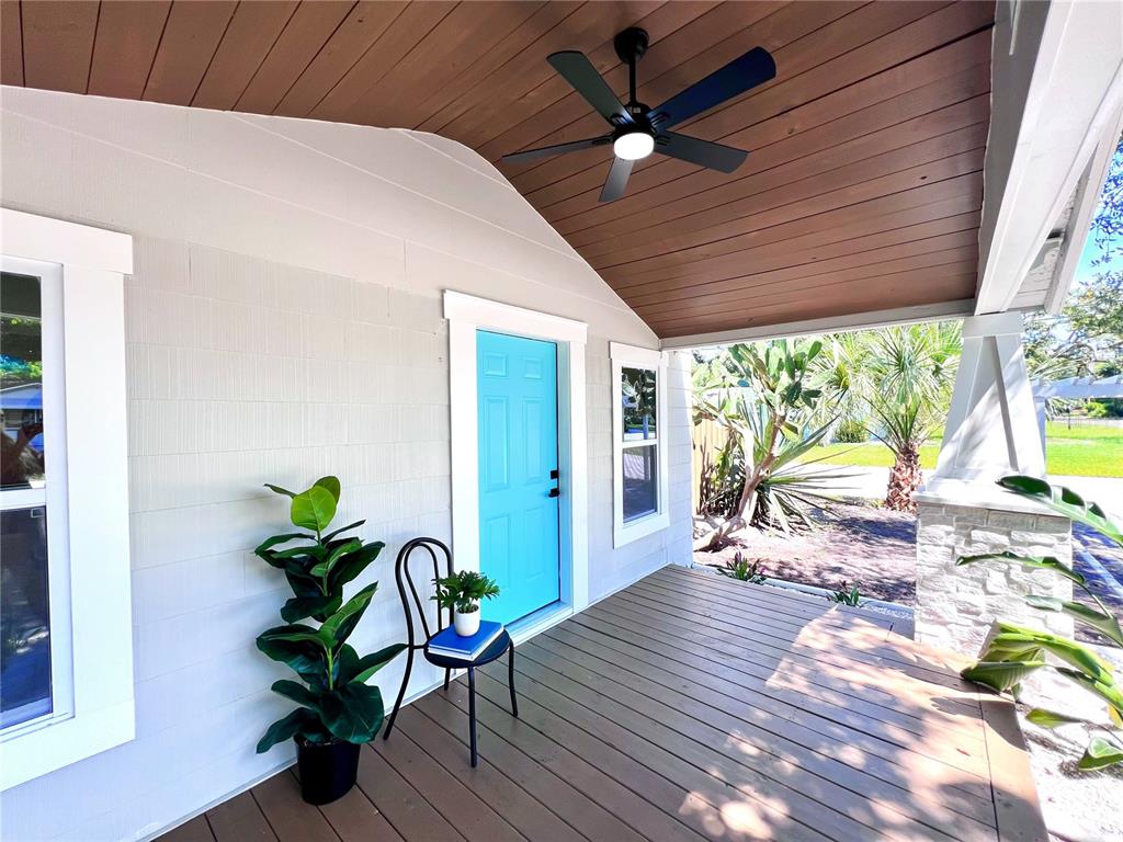 A covered front porch features a bright blue door, wood-plank ceiling, and a ceiling fan — 2427 32ND AVENUE N, ST PETERSBURG, FL