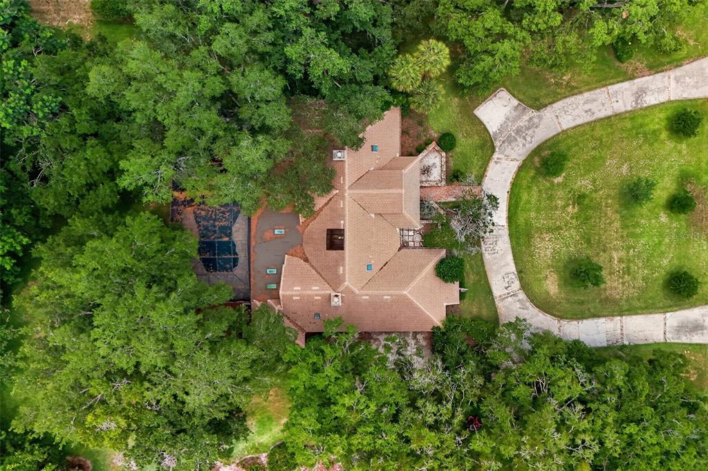An aerial view shows a house with a brown roof, a pool, and a circular driveway — 1808 WINGFIELD DRIVE, LONGWOOD, FL