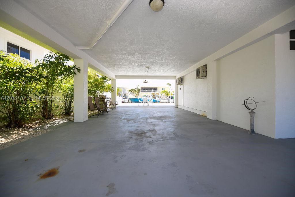 A covered outdoor patio area features a concrete floor and views of a boat dock — 177 Lorelane Pl, Key Largo FL 33037, KEY LARGO, FL