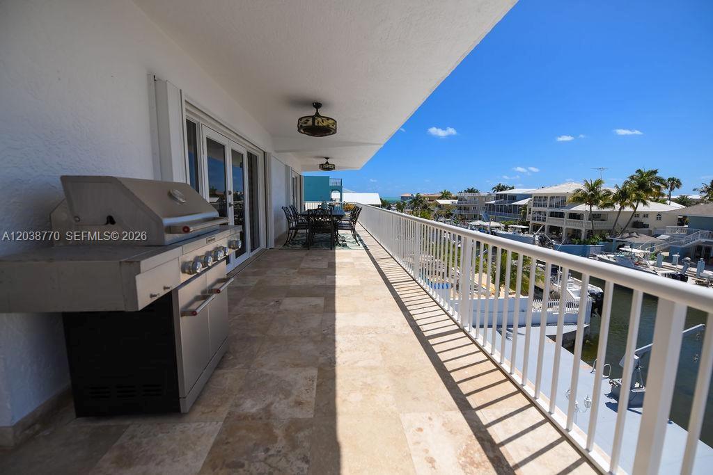 A balcony features a stainless steel grill, tile flooring, and a view of the water — 177 Lorelane Pl, Key Largo FL 33037, KEY LARGO, FL