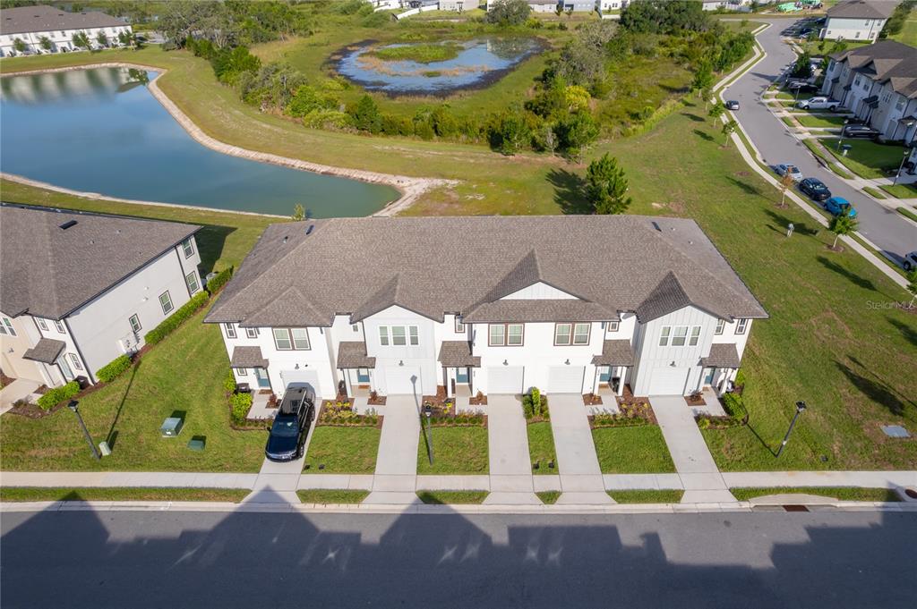 An aerial view shows a row of four townhouses with driveways facing a street — 634 LONGBOAT DRIVE, DAVENPORT, FL