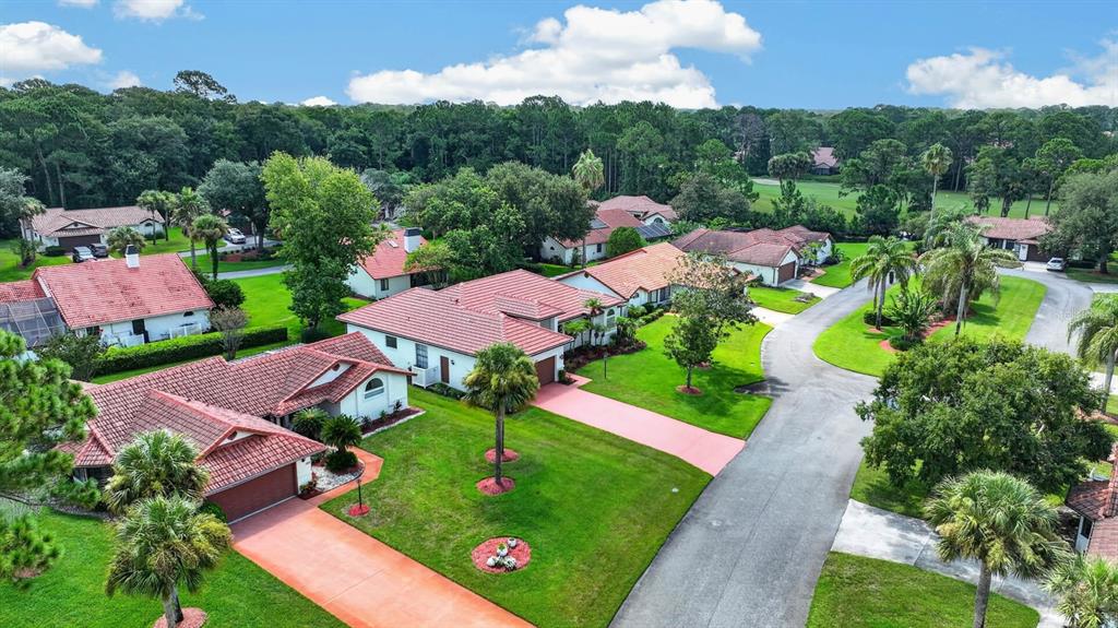 An aerial view of several single-story homes with red tile roofs and green lawns — 100 WATER TURKEY COURT, DAYTONA BEACH, FL