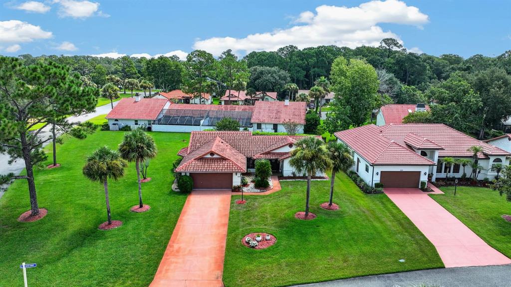 An aerial view shows two suburban houses with red tile roofs and matching driveways — 100 WATER TURKEY COURT, DAYTONA BEACH, FL