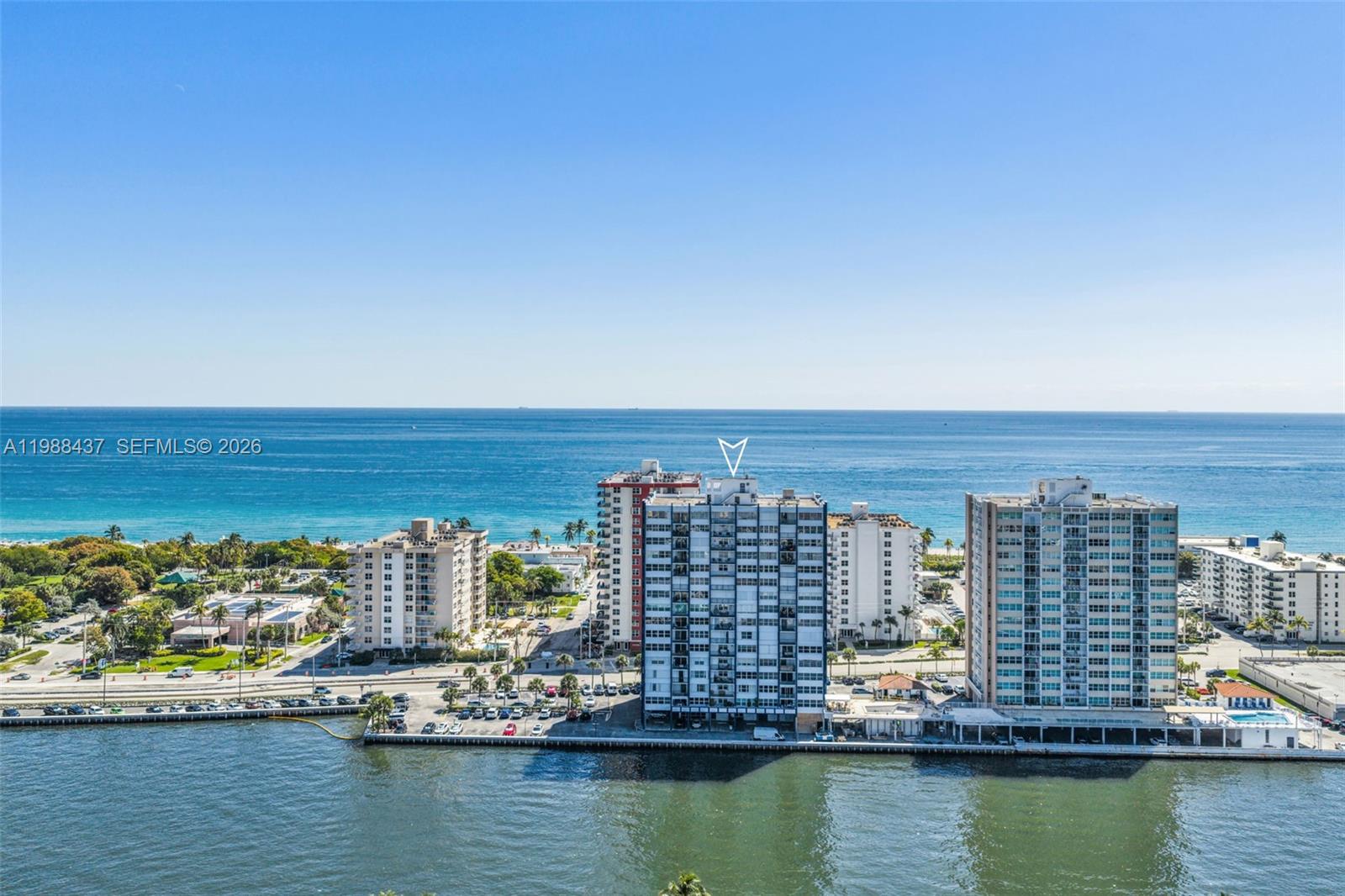 An aerial view shows high-rise apartment buildings situated along a coastline next to the ocean — 1400 S Ocean Dr # 804, Hollywood FL 33019, HOLLYWOOD, FL
