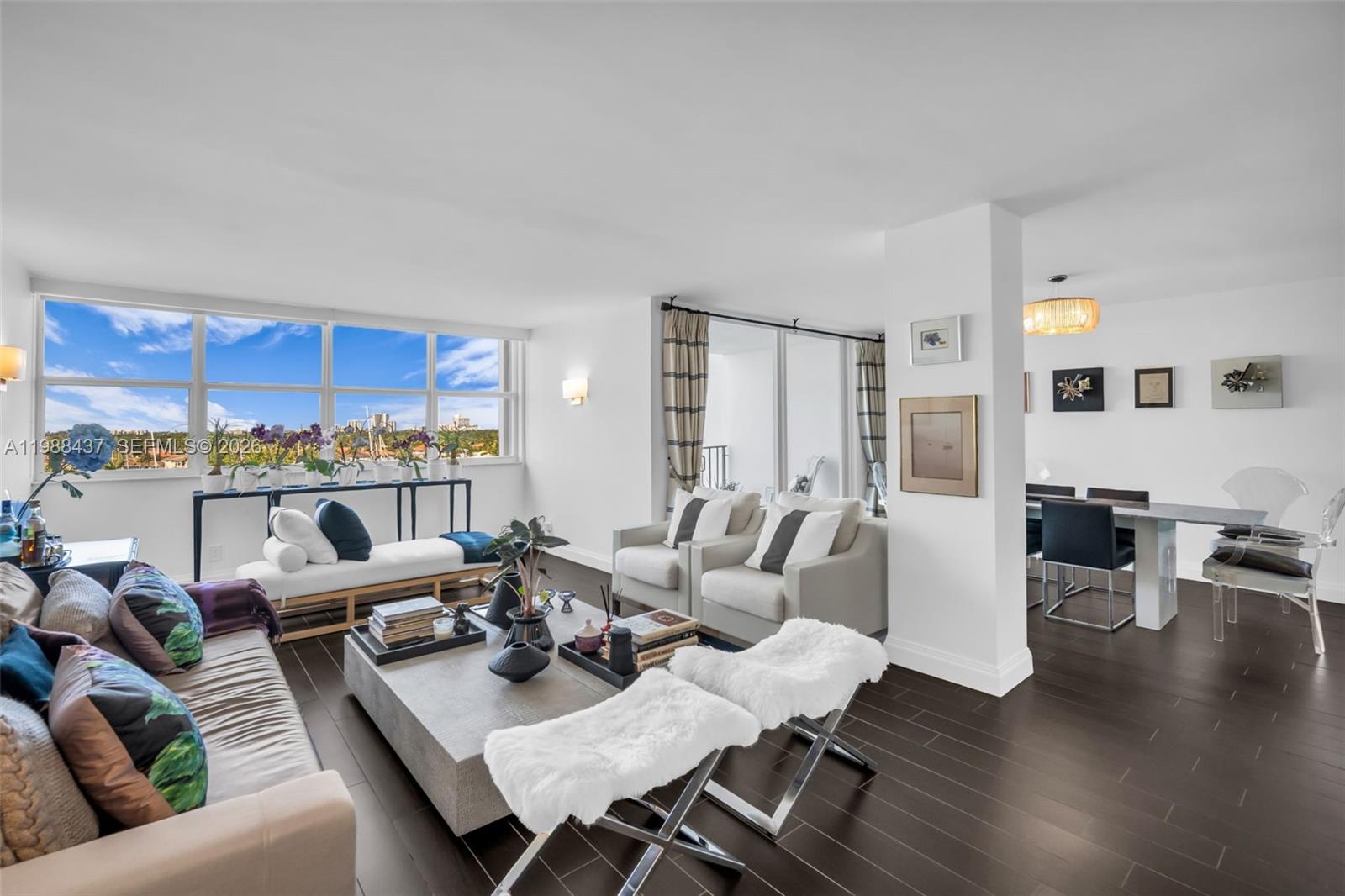 A bright living and dining area features dark wood floors, white walls, and floor-to-ceiling windows — 1400 S Ocean Dr # 804, Hollywood FL 33019, HOLLYWOOD, FL