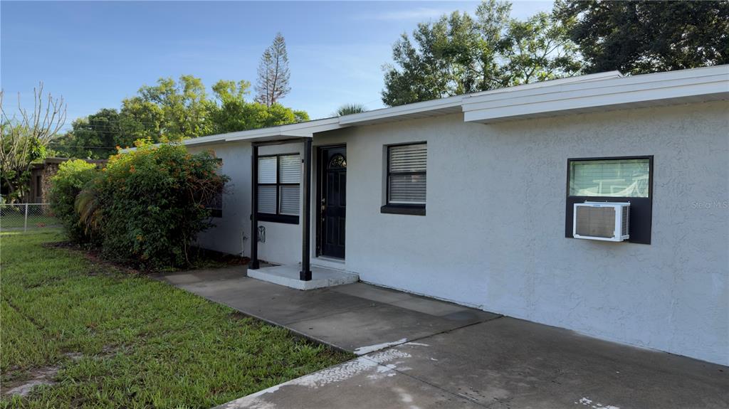 A single-story house with a white stucco exterior, black trim, and a concrete front walkway — 17 S SOLANDRA DRIVE, ORLANDO, FL