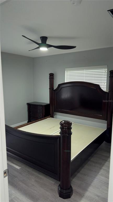 A bedroom features a dark wood poster bed, light gray flooring, and a ceiling fan — 17 S SOLANDRA DRIVE, ORLANDO, FL