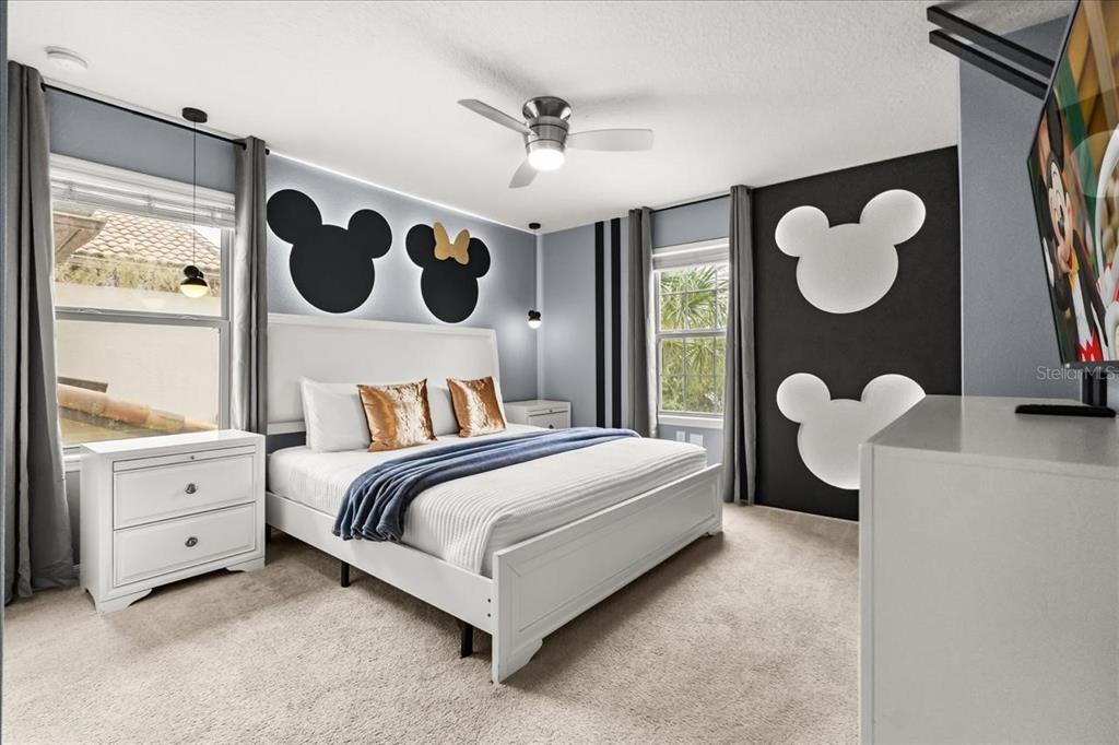 A bedroom features a white bed, Mickey Mouse wall decor, and light blue walls — 2100 ROME DRIVE, KISSIMMEE, FL