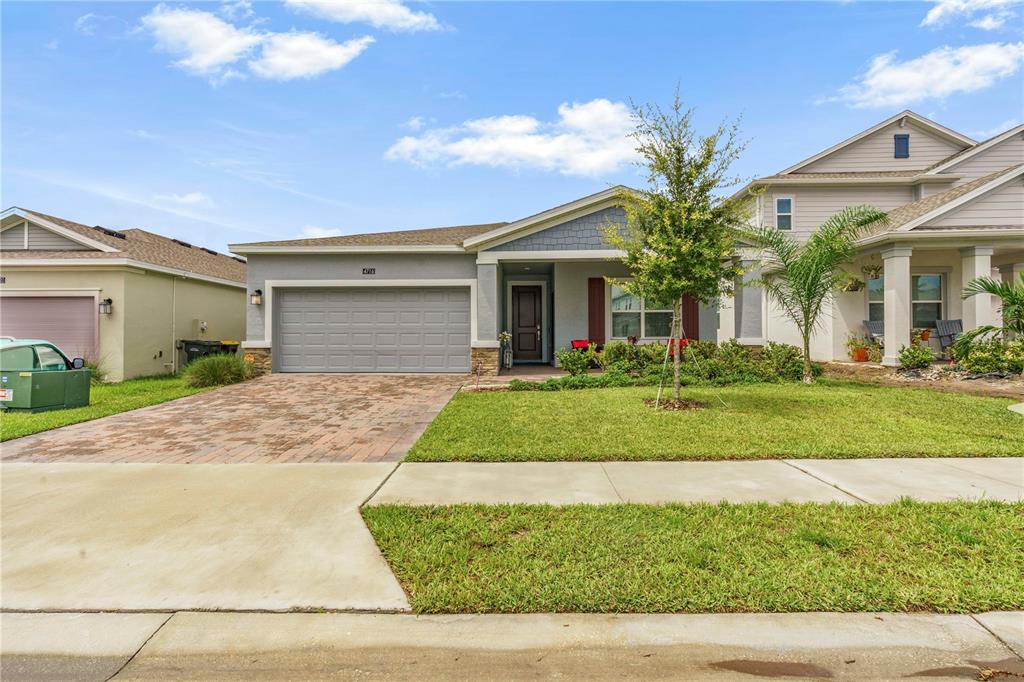 A single-story house with a gray garage, a paved driveway, and a small front lawn — 4716 WALTHAM FOREST DRIVE, DAVENPORT, FL