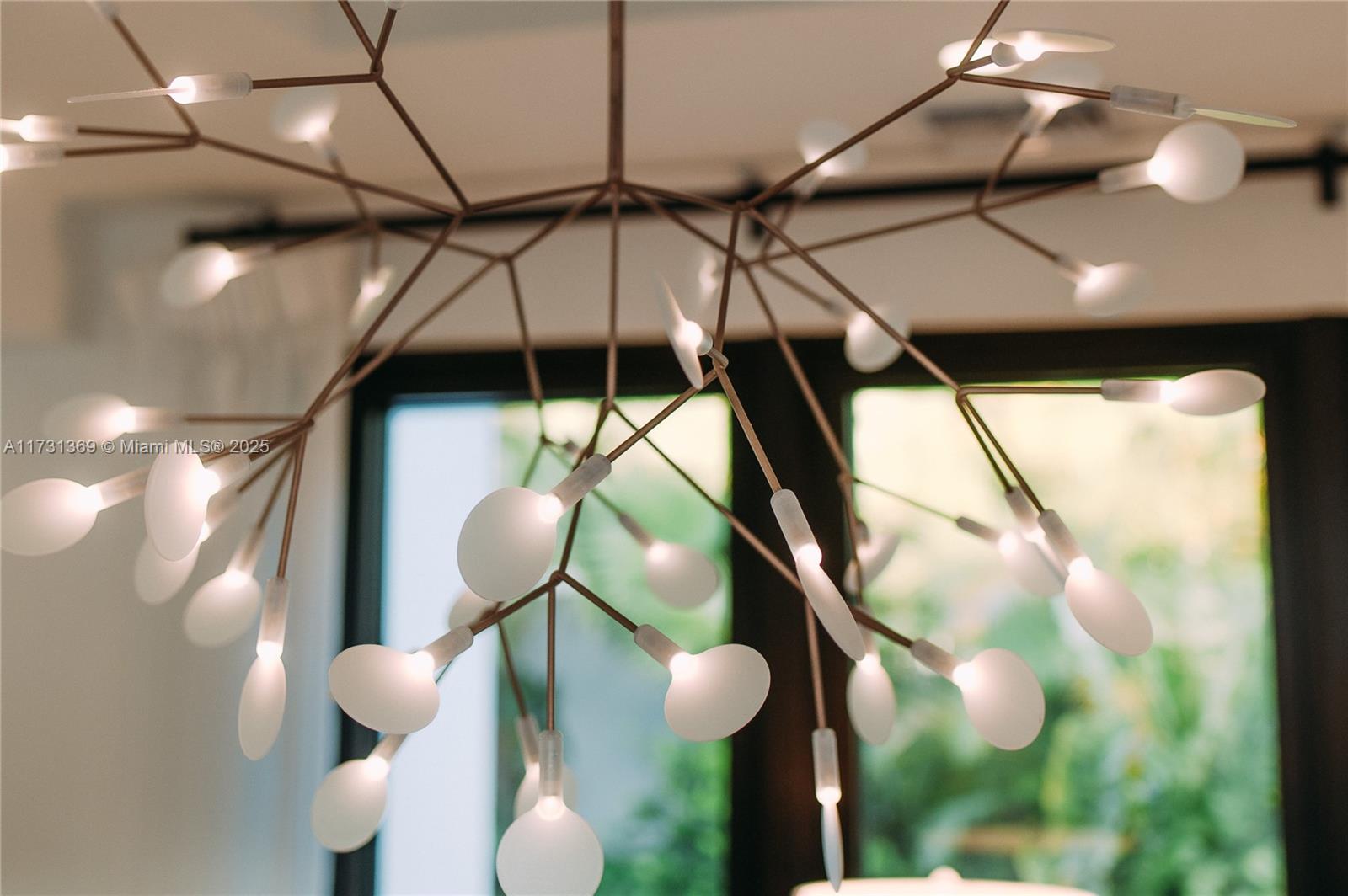 A modern, branching chandelier with numerous small, glowing, disc-shaped lights hangs from the ceiling — Villas at Pinney's Beach 2010 # 2010, FL, FL
