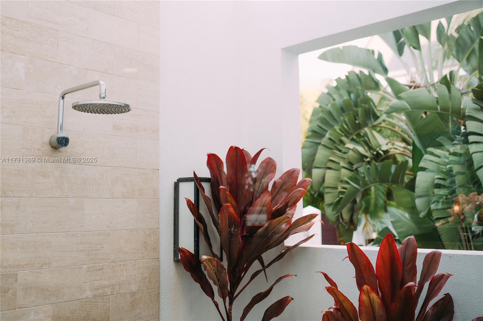 An outdoor shower features a rainfall showerhead, tiled wall, and tropical plants — Villas at Pinney's Beach 2010 # 2010, FL, FL