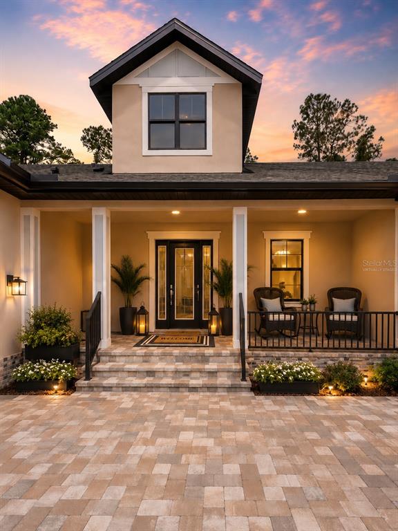 A front exterior view of a house with a covered porch, stone steps, and pavers — 5619 SUMMIT VIEW DRIVE, BROOKSVILLE, FL
