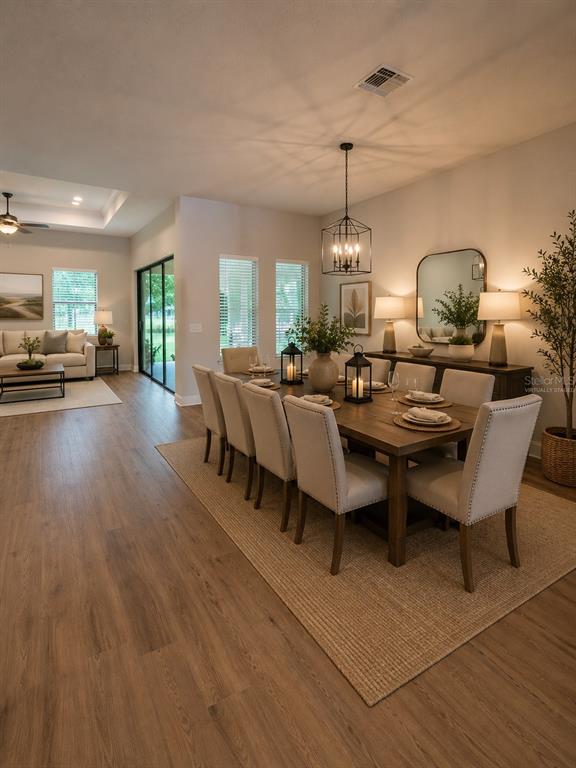 A dining room with a wooden table, upholstered chairs, and a large rectangular mirror — 5619 SUMMIT VIEW DRIVE, BROOKSVILLE, FL