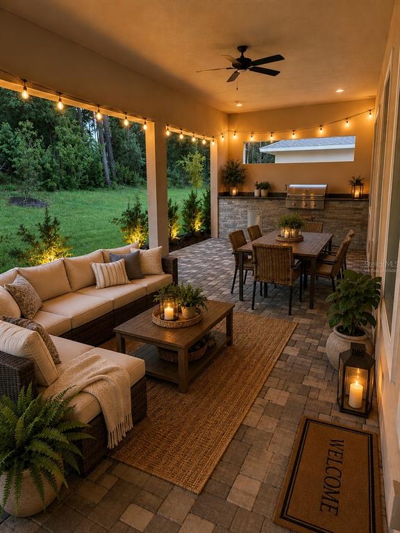 A covered patio features a wicker sectional, dining set, outdoor kitchen, and string lighting — 5619 SUMMIT VIEW DRIVE, BROOKSVILLE, FL