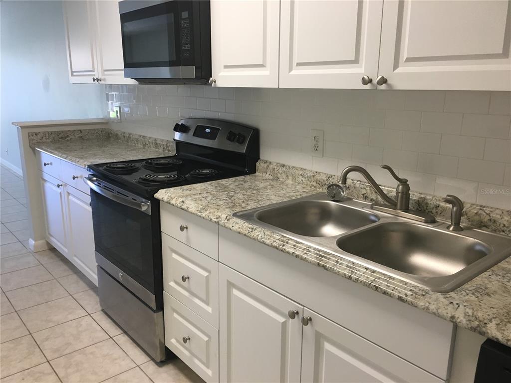 A single-story house exterior features a gray front door, large windows, and a grassy lawn — 605 NORTHLAKE BOULEVARD UNIT 75, ALTAMONTE SPRINGS, FL