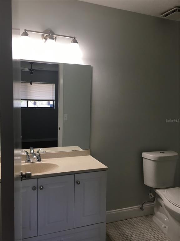 A galley kitchen features white cabinets, stainless steel appliances, and an adjacent laundry area — 605 NORTHLAKE BOULEVARD UNIT 75, ALTAMONTE SPRINGS, FL