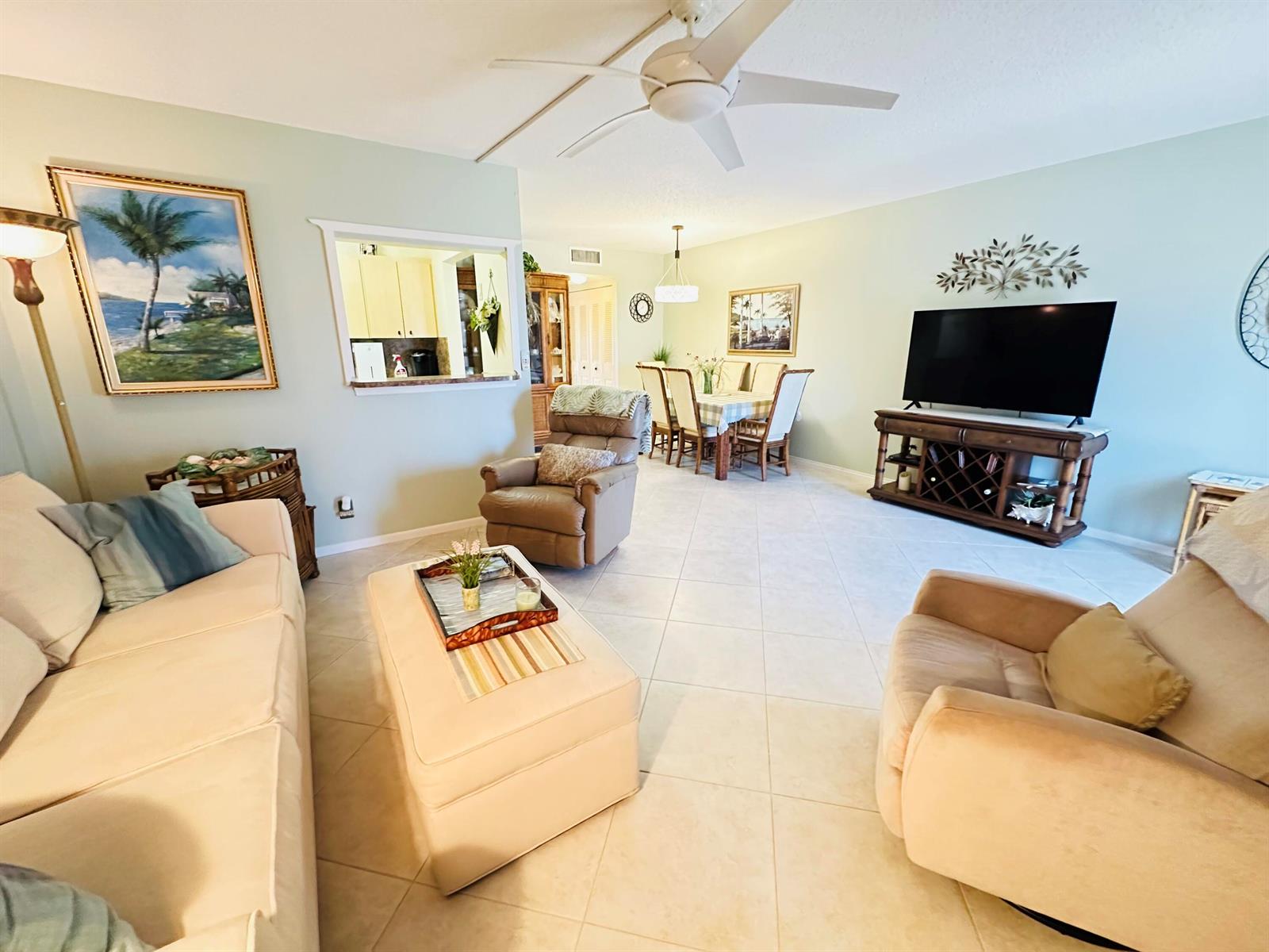 A living room with light-colored tile floors, a ceiling fan, and an open dining area — 2132 Cambridge F # 2132, Deerfield Beach FL 33442, DEERFIELD BEACH, FL