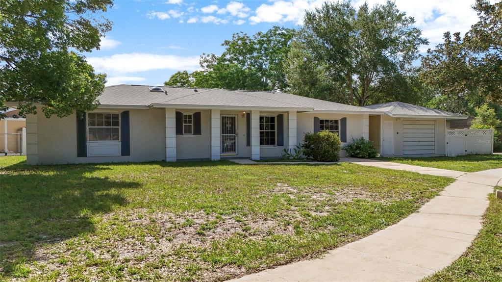A single-story house with a light-colored exterior, a front porch, and an attached garage — 142 BAYBERRY COURT, WINTER SPRINGS, FL