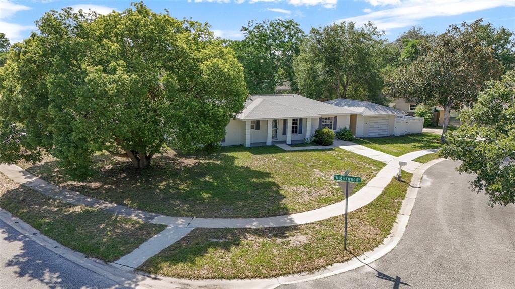 A single-story house with a large tree and a corner lot street sign — 142 BAYBERRY COURT, WINTER SPRINGS, FL