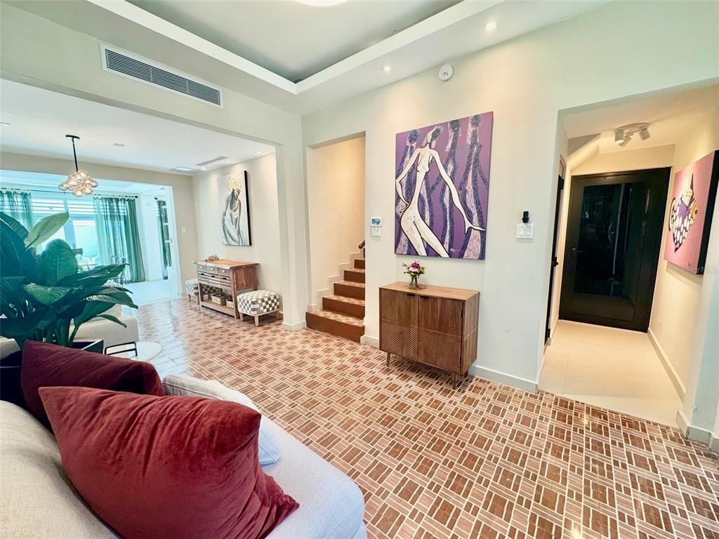 A living area features tiled floors, a wooden staircase, and modern wall art — 1419 CALLE ESTRELLA, SAN JUAN, PR