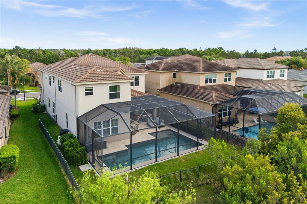 An aerial view of a two-story house with a screened-in pool and patio — 30351 TRISTANIA COURT, WESLEY CHAPEL, FL