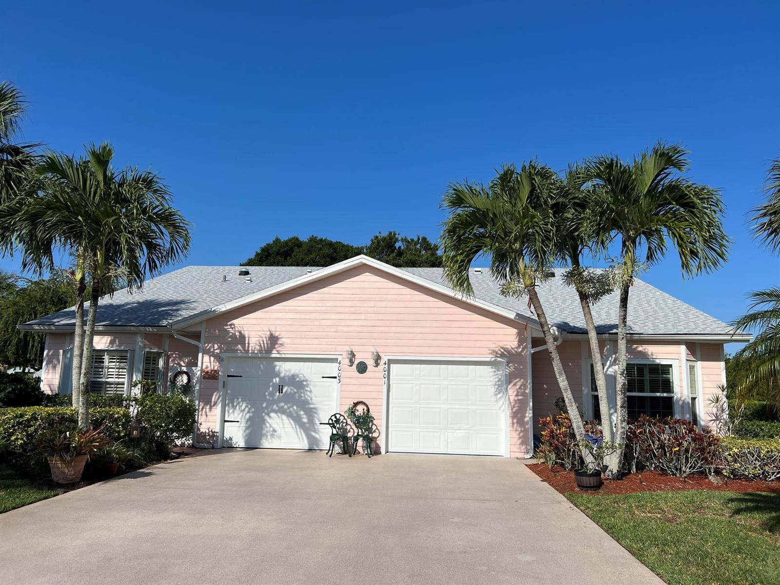 A pink single-story house with a two-car garage and palm trees in the front yard — 4001 Gator Trace Road, Fort Pierce FL 34982, FORT PIERCE, FL