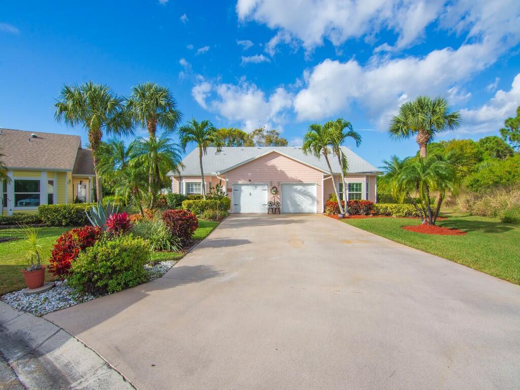 A light pink single-story house with a two-car garage and palm trees in the front yard — 4001 Gator Trace Road, Fort Pierce FL 34982, FORT PIERCE, FL