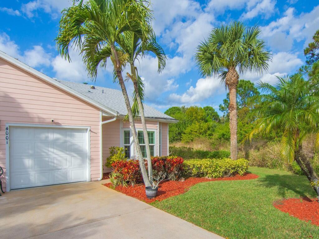 A light pink house with a white garage door and palm trees in the front yard — 4001 Gator Trace Road, Fort Pierce FL 34982, FORT PIERCE, FL