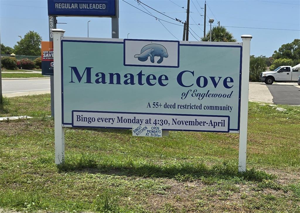 A sign for Manatee Cove of Englewood stands in a grassy area near a road — 1359 IBIS DRIVE, ENGLEWOOD, FL