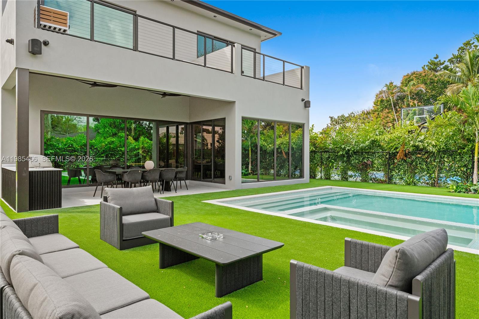 A modern two-story house features a patio, outdoor dining area, and a swimming pool — 245 NE 116th St, Miami FL 33161, MIAMI, FL