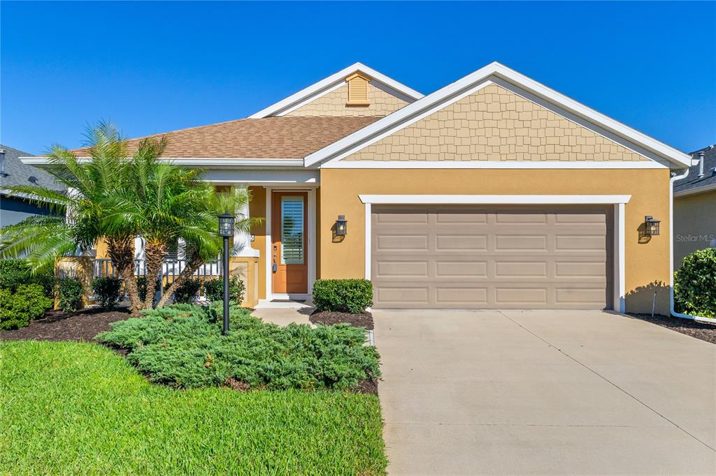 A single-story house with a tan stucco exterior, a two-car garage, and a palm tree — 3835 AUTUMN FERN TERRACE, SARASOTA, FL