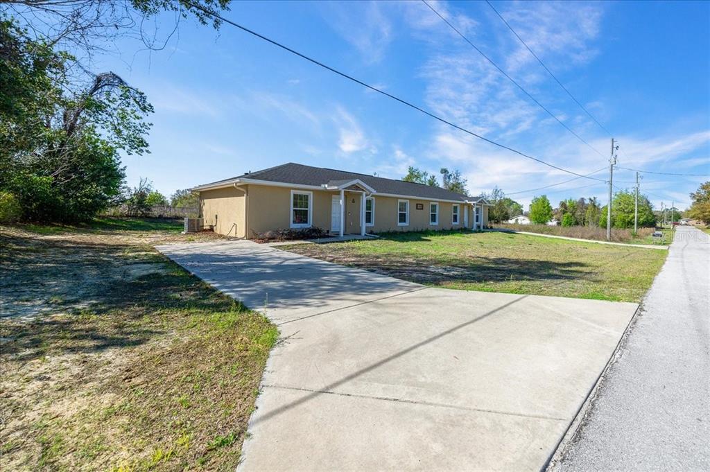 A tan, single-story house with a concrete driveway sits on a grassy lot — 5364 NW 2ND PLACE, OCALA, FL